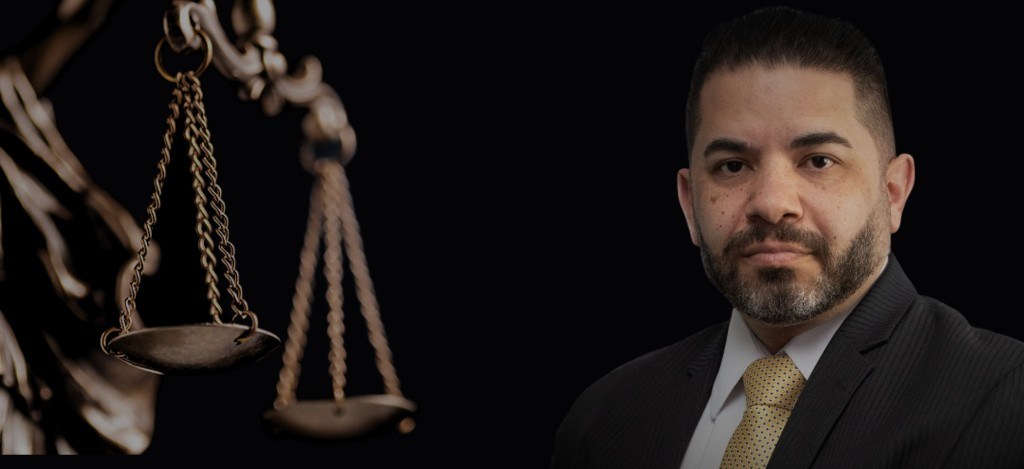Dr. Fábio Santos ao lado da balança da justiça